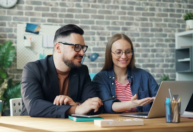 Two colleagues reviewing a project on a laptop
