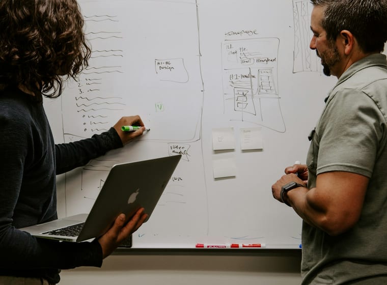 Engineers mapping an application architecture on a whiteboard