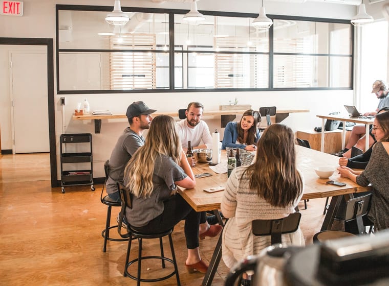 Open-plan workspace with teams collaborating at shared desks